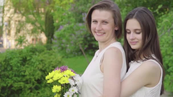 Setkání Dcera a její matka v parku. Atraktivní brunetka je objímání a její maminka s láskou a něhou — Stock video