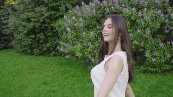 Fiatal vonzó lány szédül a kertben — Stock videók