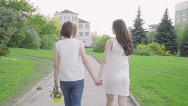 Happy woman and her young daughter walking park. Adult Mother and Daughter walking in the park — Stock Video