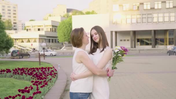 Mère et fille adulte riant et bavardant dans le parc par une journée ensoleillée. attrayant brunette est étreignant sa mère avec amour et tendresse — Video