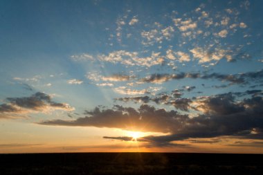 25 de Mayo, La Pampa, Arjantin 'de, çölde bulutlu gün batımı.