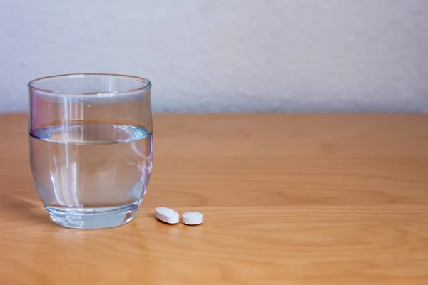 Ποτήρι Νερό Και Χάπια Ξύλινο Τραπέζι Λευκό Φόντο Και Χώρο — Φωτογραφία Αρχείου