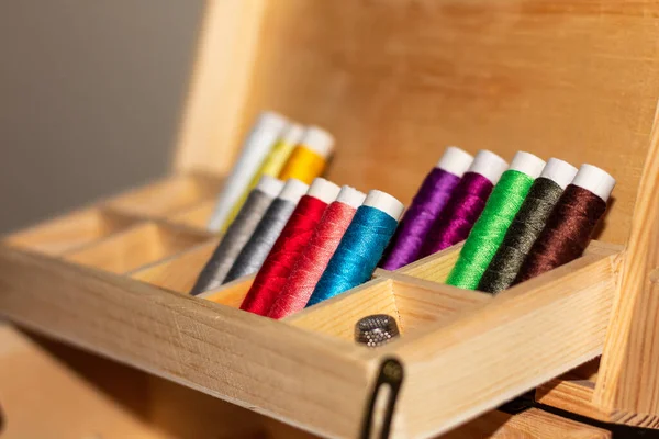 在木制缝纫套件内 用多种颜色的线轴进行特写 — 图库照片