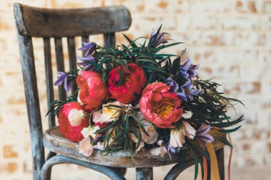                 Güzel bir buket çiçek, ahşap, antika bir sandalyede uzanıyor, yakın plan.