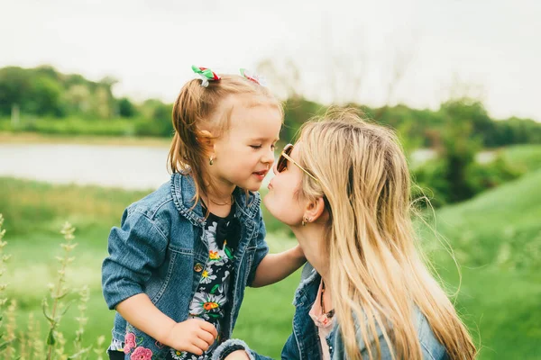 Mama i młoda córka w naturze, moment pocałunku — Zdjęcie stockowe