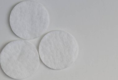  Beyaz kağıt arka plan ve sol alt köşede üç pamuk pedi..