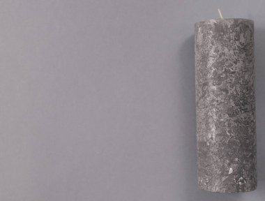 Gri arkaplanda gri bir mum, sağda.
