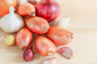 Tahta bir masada soğan ve sarımsak..