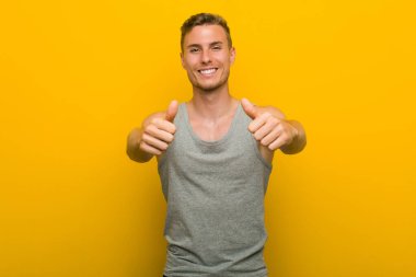 Başparmakları havada, bir şey için tezahürat yapan, destek olan ve saygı duyan beyaz, genç bir sporcu..