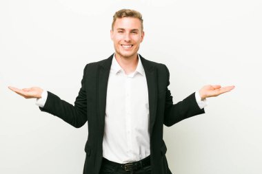 Genç kafkas iş adamı kollarıyla ölçeklendiriyor, mutlu ve kendinden emin hissediyor.