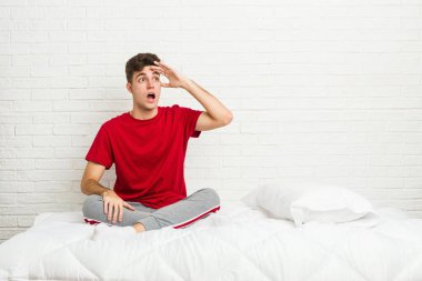 Genç bir öğrenci yatağında uzaklara bakıyor ve elini alnına koyuyor..