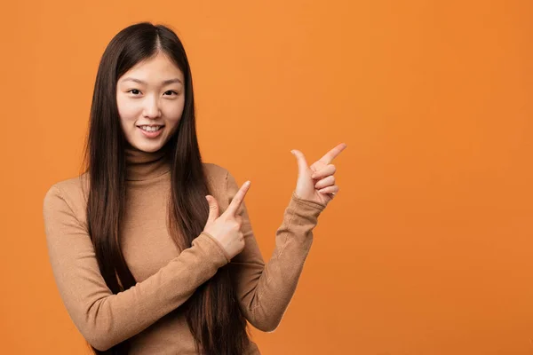 Junge Hübsche Chinesin Zeigt Mit Den Zeigefingern Auf Einen Kopierraum — Stockfoto