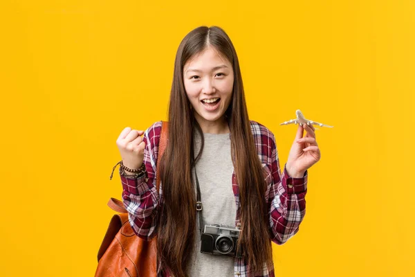 Young Asian Woman Holding Airplane Icon Cheering Carefree Excited Victory — Stock Photo, Image