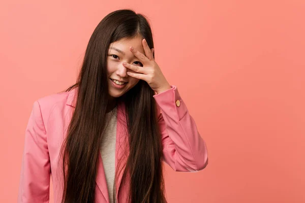Pembe Takım Elbiseli Genç Çinli Kadın Kameraya Parmaklarıyla Göz Kırpıyor — Stok fotoğraf