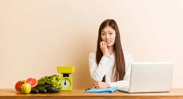 Jovem Nutricionista Mulher Chinesa Trabalhando Com Seu Laptop Mordendo Unhas — Fotografia de Stock