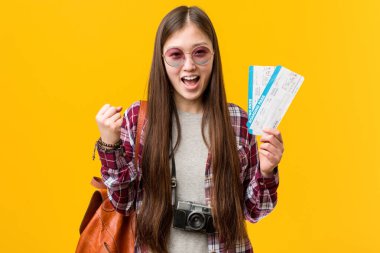 Asyalı genç bir kadın uçak biletlerini tutuyor tasasız ve heyecanlı bir şekilde tezahürat yapıyor. Zafer konsepti.