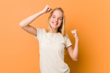 Cute and natural teenager woman celebrating a special day, jumps and raise arms with energy.