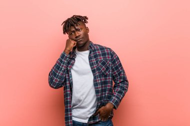 Üzgün ve dalgın hisseden genç Afrikalı siyahi adam, kopyalama alanına bakıyor..