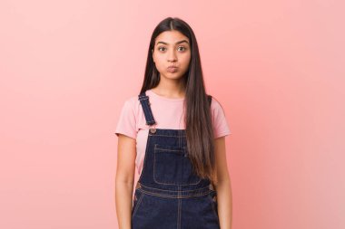 Kot pantolon giyen genç, güzel bir Arap kadın yanaklarına sakso çekiyor, yorgun bir ifade takınıyor. Yüz ifadesi kavramı.