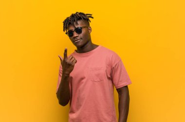 Gündelik siyah gözlüklü genç adam sanki seni davet ediyormuş gibi seni işaret ediyor..