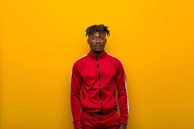 Sarı arka planda duran Afrikalı genç bir sporcu.