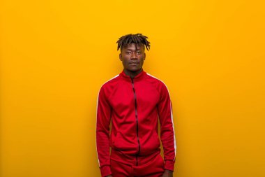 Young african sporty man standing against a yellow background clipart