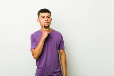 Genç İspanyol adam şüpheli ve şüpheci ifade yan bakıyor.