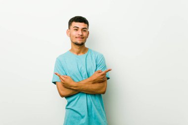 Genç İspanyol adam yan noktalar, iki seçenek arasında seçim yapmaya çalışıyor.