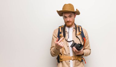 Genç kızıl saçlı kaşif gelmek için davet ediyor. Bir kamera tutuyorum..