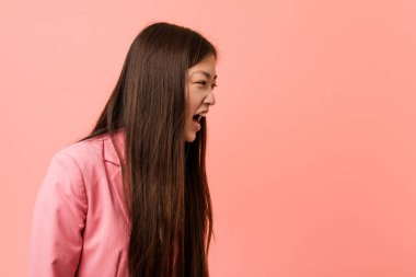 Pembe takım elbiseli genç Çinli kadın fotokopi odasına doğru bağırıyor.