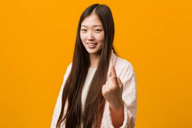 Pijamalı genç Çinli kadın sanki seni davet ediyormuş gibi seni işaret ediyor..