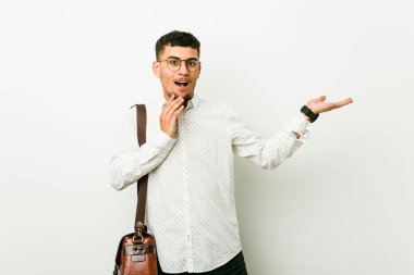 Latin asıllı, sıradan bir iş adamı avucunun içinde fotokopi masası tutuyor, el üstünde tutuyor. Şaşırmış ve mutlu..