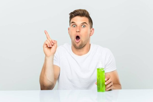 Молодой красивый мужчина с бутылкой алоэ вера, имеющий отличную идею, концепцию творчества
.