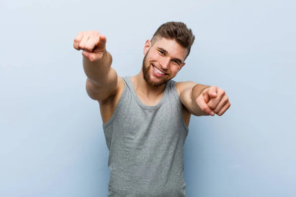 Junger Gutaussehender Fitnessmann Lächelt Fröhlich Und Zeigt Nach Vorne — Stockfoto