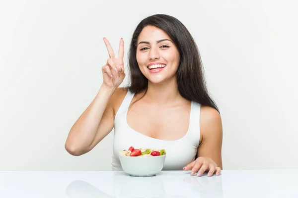 Giovane Donna Ispanica Mangiare Una Ciotola Frutta Mostrando Segno Vittoria — Foto Stock