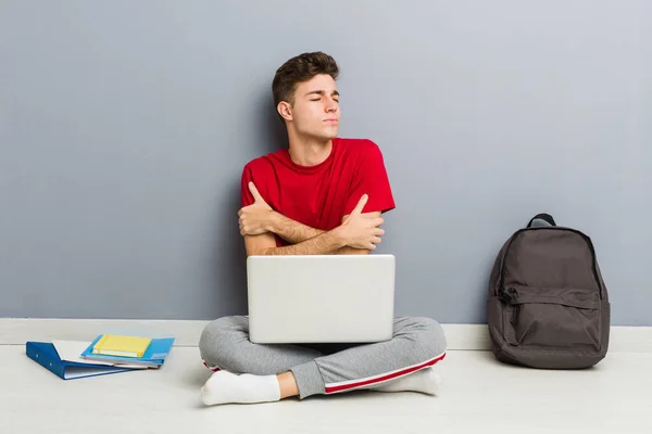 Jonge student man zittend op zijn huis vloer met een laptop — Stockfoto