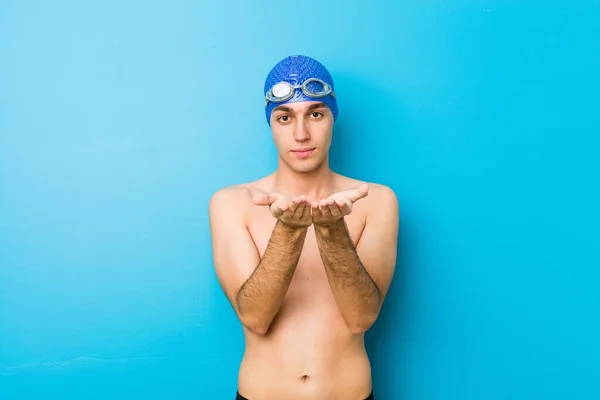 Joven Nadador Sosteniendo Algo Con Las Palmas Las Manos Ofreciendo — Foto de Stock