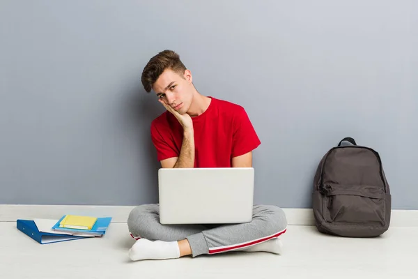 Jonge student man zittend op zijn huis vloer met een laptop — Stockfoto