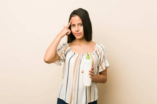 Junge Hispanische Frau Hält Eine Cremeflasche Der Hand Und Zeigt — Stockfoto