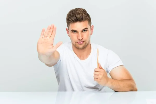 Ung Man Som Håller Tandborste Stående Med Utsträckt Hand Visar — Stockfoto