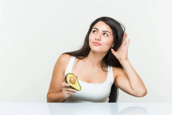 Mujer Hispana Joven Sosteniendo Aguacate Tratando Escuchar Chisme —  Fotos de Stock