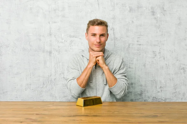 Joven Hombre Guapo Sosteniendo Lingote Oro Una Mesa Mantiene Las — Foto de Stock