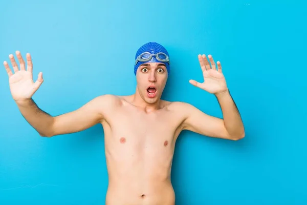 Young swimmer man being shocked due to an imminent danger
