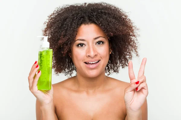 Young African American Woman Holding Aloe Vera Bottle Showing Number — Stock Photo, Image