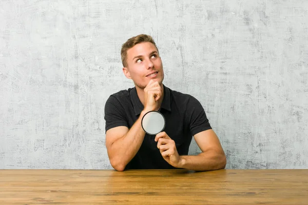 Jonge Knappe Man Met Een Vergrootglas Zoek Zijwaarts Met Twijfelachtige — Stockfoto