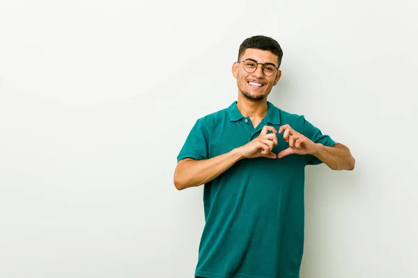 年轻的西班牙男子微笑 并显示一个心脏形状与手 — 图库照片