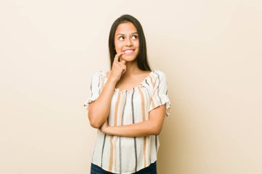 Genç İspanyol kadın bir kopya alanı bakarak bir şey hakkında düşünme rahat.