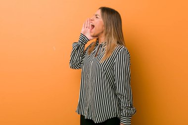 Genç otantik karizmatik gerçek insanlar kadın bir duvara karşı bağırarak ve açık ağız yakınında palmiye tutarak.