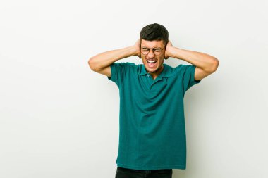 Çok yüksek ses duymamaya çalışan elleri ile kulakları kapatan genç İspanyol adam.