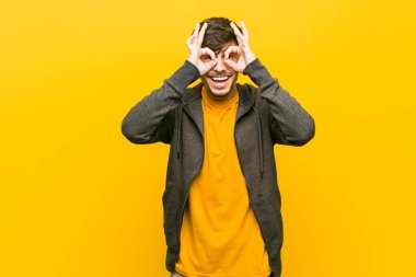 Genç İspanyol rahat adam gözleri üzerinde tamam işareti gösteren